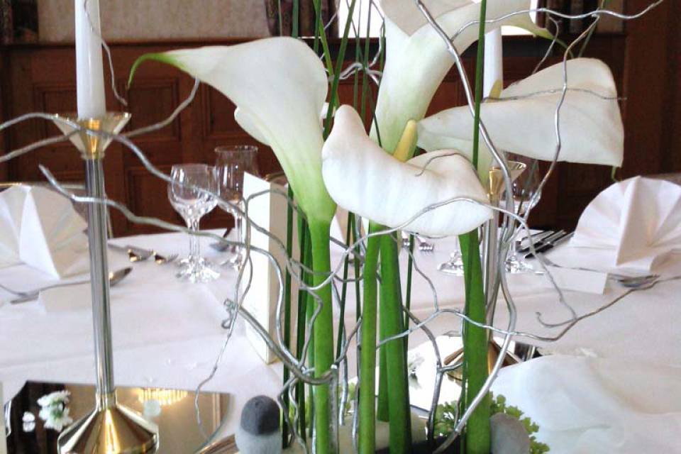 Blumendeko auf einem gedeckten Tisch im Restaurant